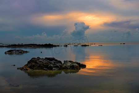 美丽黄昏日出时海中的石头