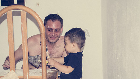 父亲和一岁半的男婴粉刷房间