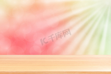 空木桌地板在柔和的粉红色散景灯光束闪耀渐变背景上，木板空在绿色粉红色散景彩色灯光照耀下，彩色散景灯渐变柔和，用于横幅广告