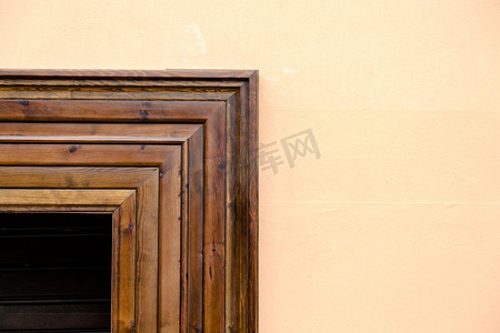 封闭窗户摄影照片_深色木质封闭窗户与淡奶油色墙壁形成鲜明对比