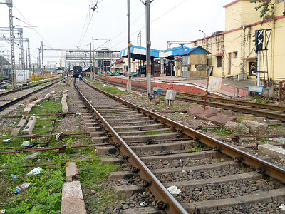 拥挤的车站摄影照片_白天在 Howrah 车站车棚区，从火车站站台附近的铁轨枕木看印度铁路轨道的低角度视图。