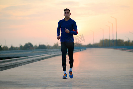 年轻的运动员在日落时分奔跑。