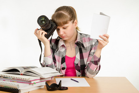 横版招商手册摄影照片_女孩阅读手册和教程，试图学习如何拍照