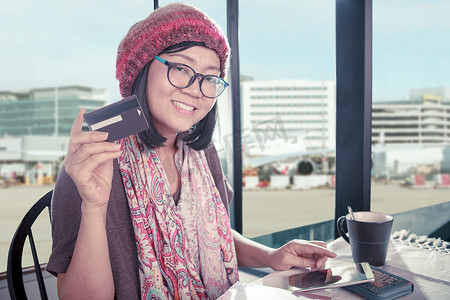 手持信用卡的亚洲女性幸福笑脸