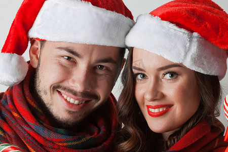 圣诞帽围巾摄影照片_戴着圣诞帽的圣诞情侣