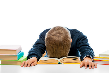 一个桌子旁的小学生看书睡着了，笑