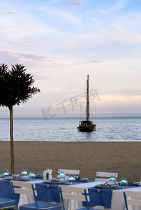 露台餐厅摄影照片_传统欧洲地中海餐厅的夏日露台海滨景观，天空背景中的游艇