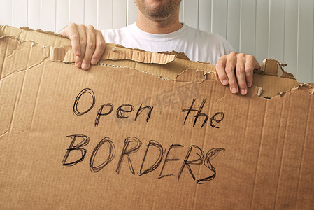 拿着纸板的难民与打开边界请求