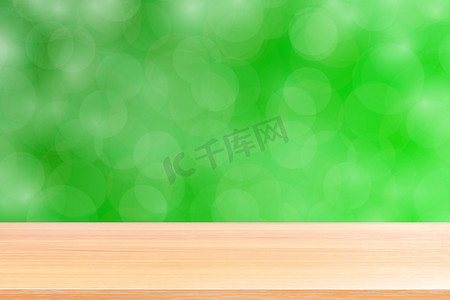 空木桌地板在模糊的散景软绿色渐变背景上，木板空在绿色散景彩色光罩上，彩色散景灯渐变软，用于横幅广告产品
