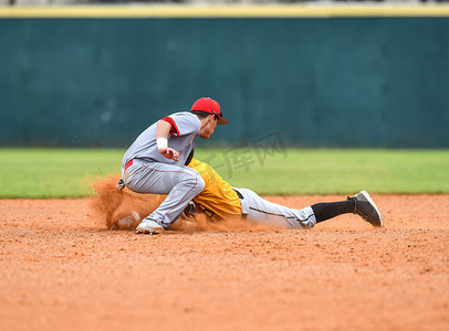 内野手摄影照片_打棒球的年轻运动男孩