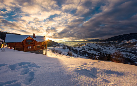 日出时深雪中的木屋
