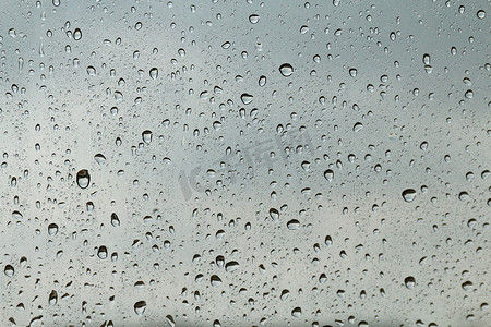 窗玻璃质地上的水滴新鲜凝结，雨季湿背景冷却感觉和寒冷，雨滴质地湿透明气泡
