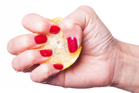 手用修剪整齐的指甲在白色上挤柠檬