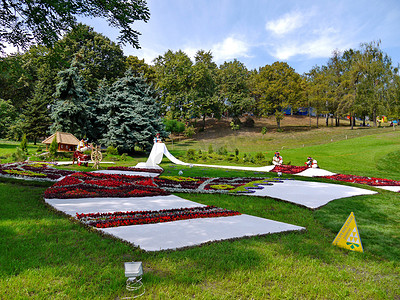 绣花图案的摄影照片_以绣花毛巾形式装饰的花坛，乌克兰女孩在花圈和绿草背景中