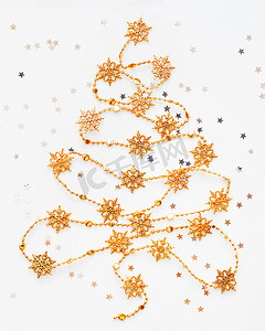 圣诞树由金色雪花花环和银星制成
