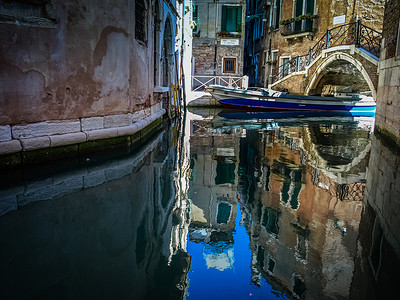 船在水中倒影摄影照片_意大利威尼斯的房屋及其在水中的倒影
