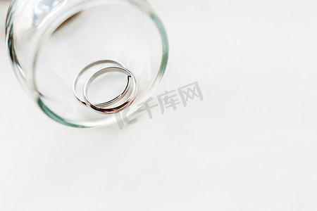 在透明玻璃中的结婚金戒指。