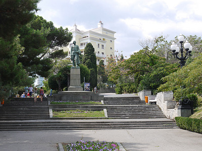 楼梯顶部的马克西姆·高尔基纪念碑以树木和一栋高大的白色建筑为背景