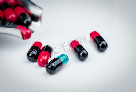 选择性聚焦蓝绿色胶囊药丸和带红黑胶囊的药物托盘。