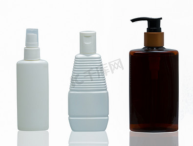三个不同类型瓶盖的白色和棕色塑料化妆品瓶：白色背景上隔离的泵、喷雾和瓶盖，带有空白标签和复制空间