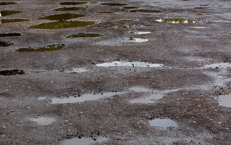 夏日雨后多水坑的颠簸损坏路面沥青