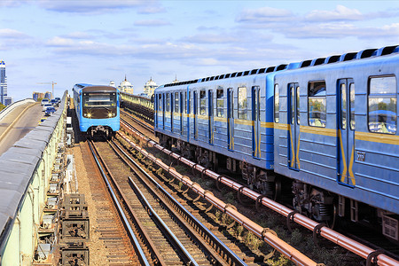 两列地铁列车沿着基辅的地铁桥相向而行，横跨第聂伯河。