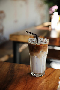 光明牛奶易拉宝摄影照片_咖啡店木头上的冰拿铁咖啡