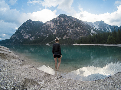 妇女们站在 Braies Lake Lago 的壮丽景色旁，群山倒映在意大利阿尔卑斯山白云岩的湖水中。