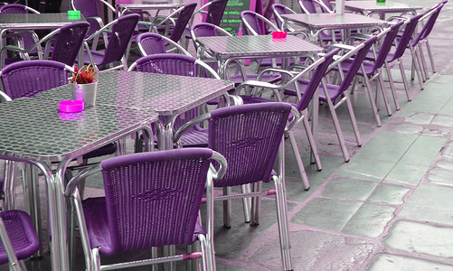 空荡荡的欧洲街头咖啡馆，有紫色的椅子和桌子，有选择的焦点