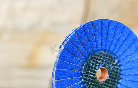在不锋利的浅米色背景上，在木头和金属上拍打蓝色砂轮。