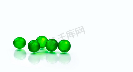 胃胀摄影照片_五个绿色圆形软胶囊药丸隔离在白色背景与复制空间。