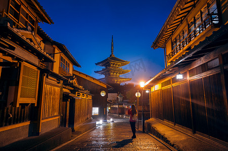 女人在日本京都的八坂塔和三年坂街拍照。