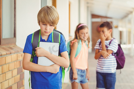 学校朋友在走廊里欺负一个悲伤的男孩