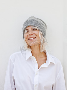 快乐的年轻女人在温暖的灰色无檐小便帽。