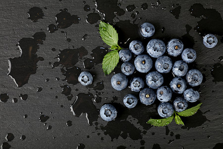 蓝莓落摄影照片_在黑板上关闭洗过的新鲜蓝莓