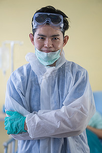 微笑的亚洲男医生下班后摘下外科口罩