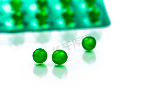 带空间的泡罩包装模糊背景上的绿色圆形软胶囊药丸。