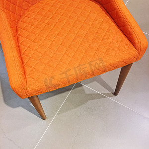 橙色客厅摄影照片_在瓷砖地板上的亮橙色扶手椅
