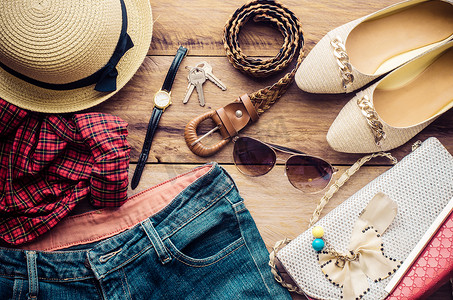 度假少女的配饰、帽子、时尚的夏季太阳镜、皮包、鞋子和木地板上的服装。