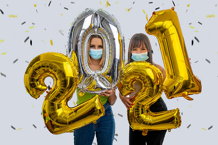 气球的2021摄影照片_女孩们戴着口罩庆祝 2021 年新年
