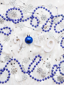 圣诞节和新年背景与数字 2019，银色和蓝色装饰品和灯泡。