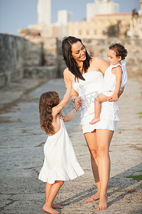 穿着白色衣服的母亲和她的女儿们沿着卡塔根散步