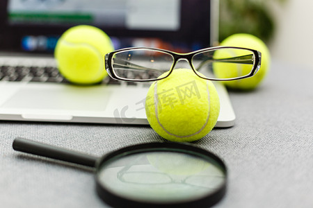 笔记本电脑、运动器材、网球、体育管理白桌上的眼镜的顶视图。经营理念。