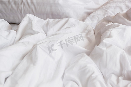 床和被子摄影照片_床上白色枕头的顶视图和皱纹凌乱的毯子我