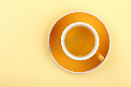 蜜桃乌龙摄影照片_茶托上的黄色绿乌龙茶杯