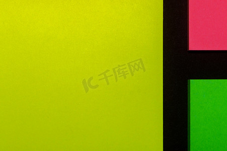 黑纸上的绿色、黄色和粉红色色调彩色办公室贴纸。 