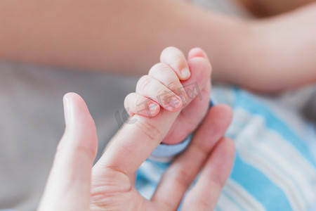 刚出生的婴儿握着他母亲的手指。