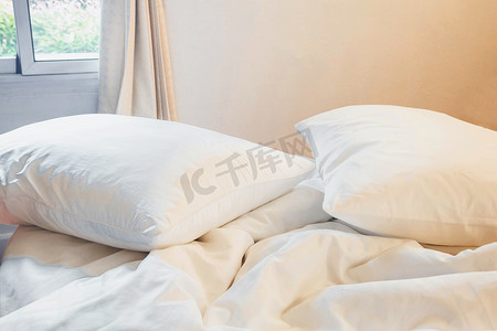 床和被子摄影照片_白色枕头和毯子，卧室床上皱纹凌乱