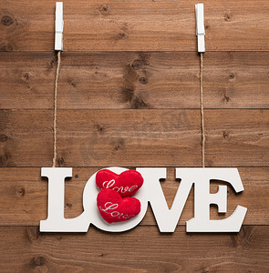 白色爱情文字用绳子和衣夹挂在木制背景上