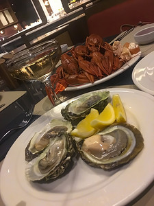 餐桌上的美食摄影照片_牡蛎龙虾小龙虾小龙虾海鲜和餐桌上的香槟